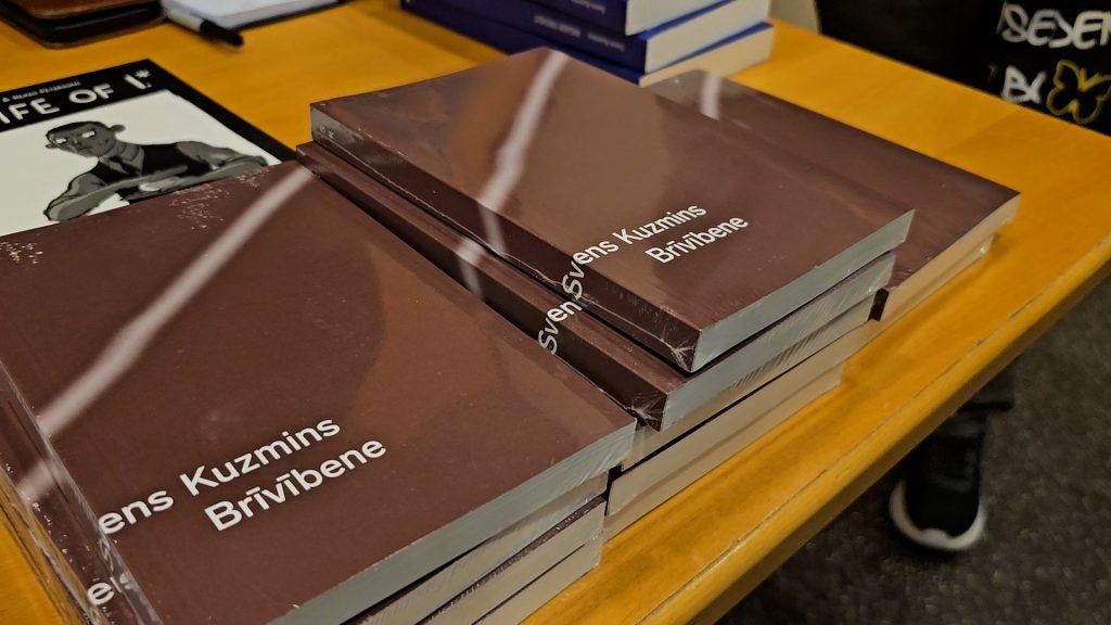 Uz galda sakrauti rakstnieka Svena Kuzmina romāna “Brīvībene” eksemplāri.