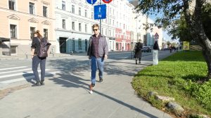 Cilvēks ar redzes traucējumiem pārvietojas pa pilsētas ietvi ar balto spieķi