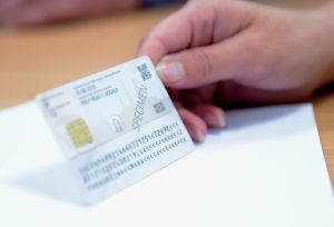 Persona rokā tur Latvijas personas apliecību jeb eID karti