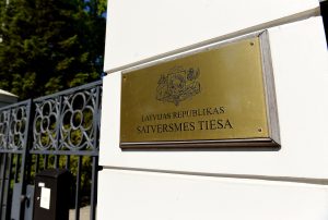 Latvijas Republikas Satversmes tiesas plāksne ar valsts ģerboni pie tiesas ēkas ieejas.