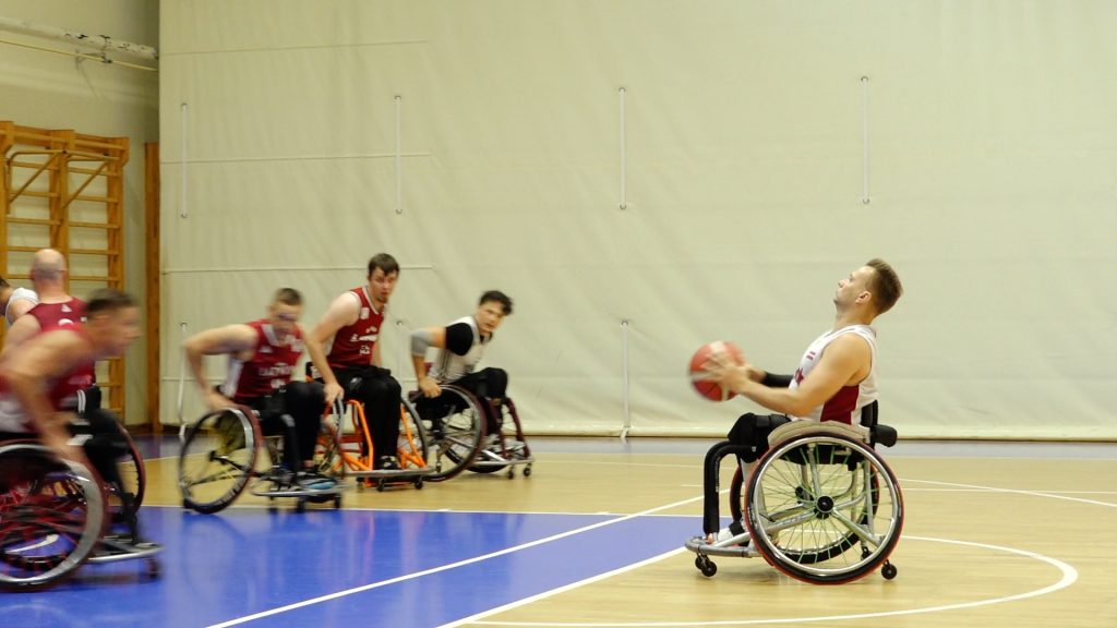 Ratiņbasketbola spēlētāji treniņā sporta zālē