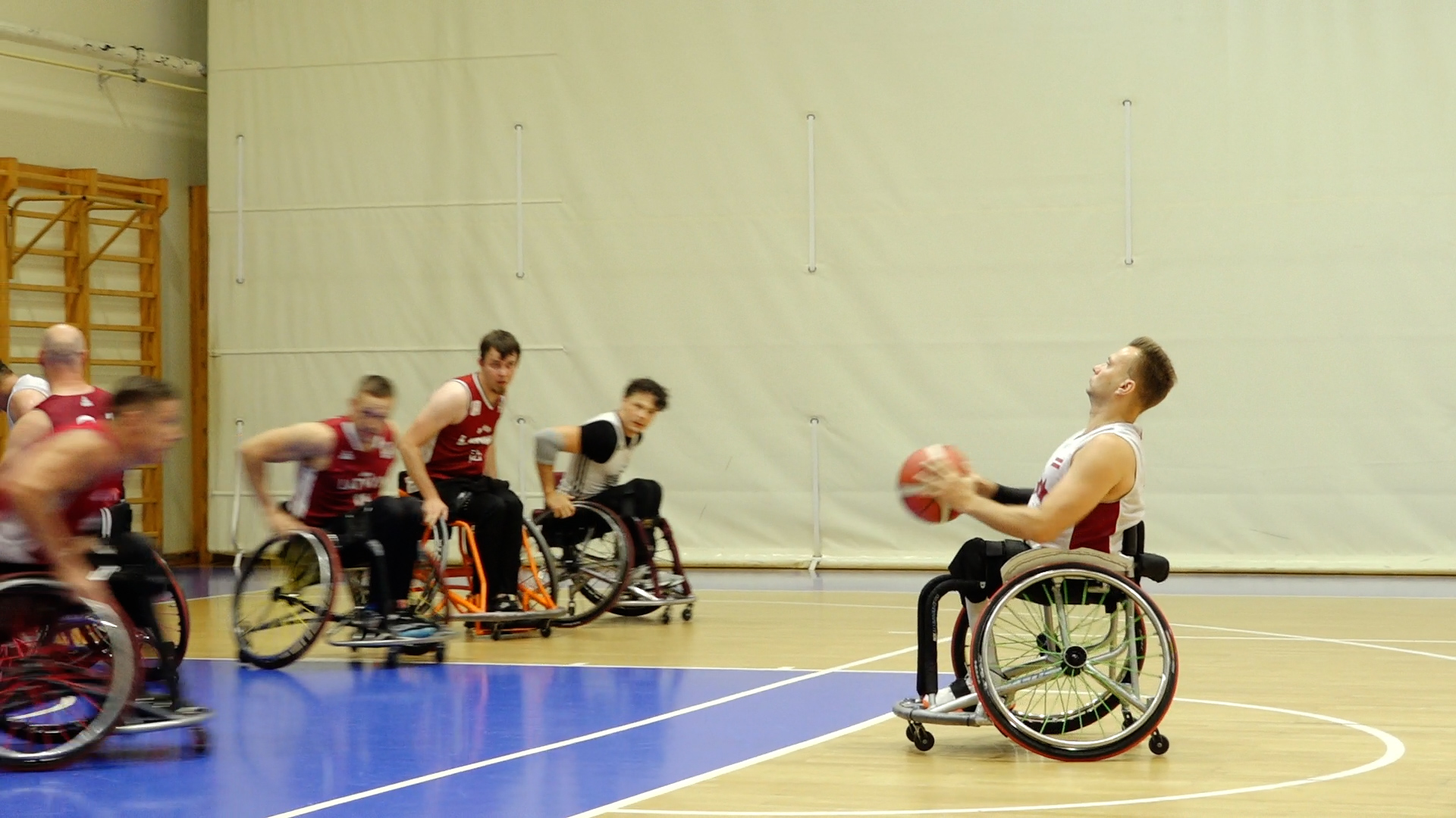 Ratiņbasketbola spēlētāji treniņā sporta zālē