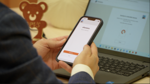 Persona izmanto eParaksts mobile lietotni viedtālrunī, lai elektroniski parakstītu dokumentu datorā.