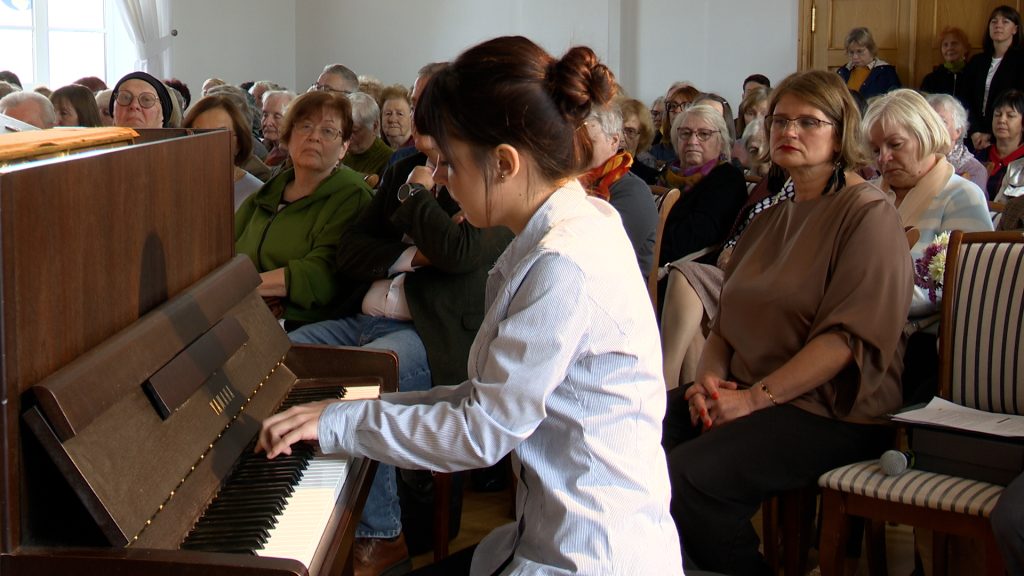 Jauna pianiste spēlē klavieres Grāmatu svētku pasākumā