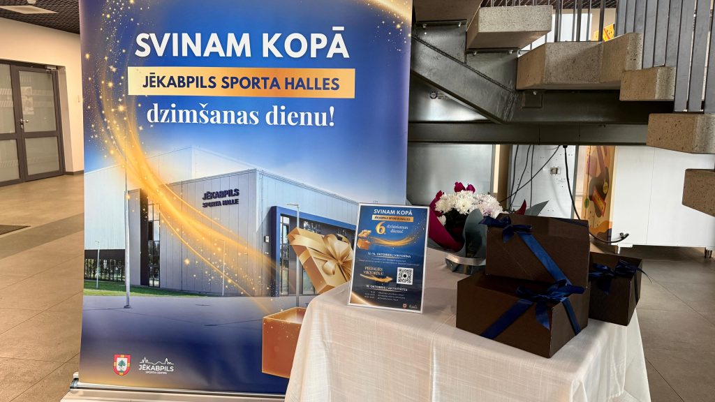 Jēkabpils Sporta halles sestās dzimšanas dienas plakāts, ziedi un dāvanu kastes.