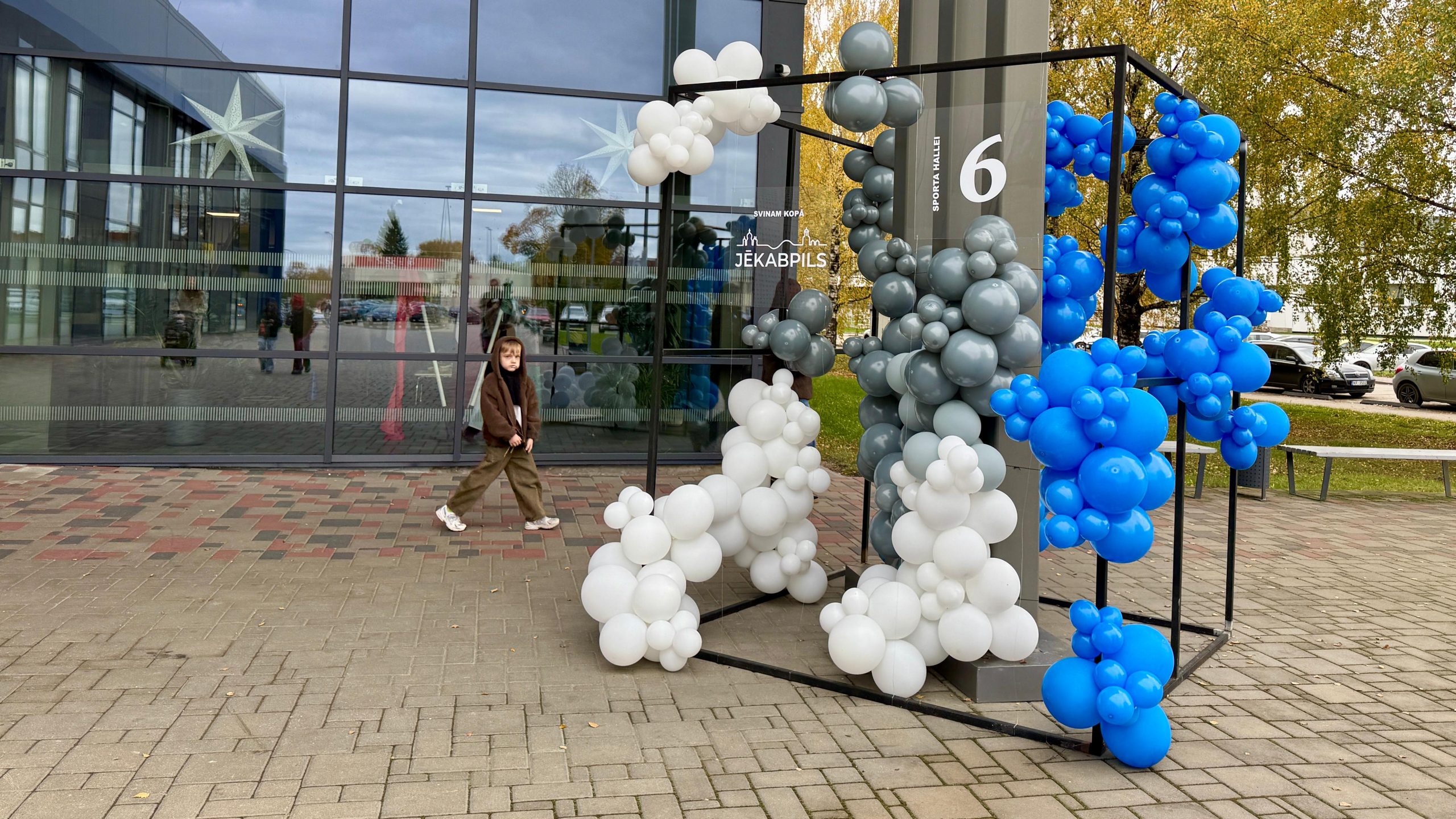 Zilu, baltu un pelēku balonu kompozīcija ar ciparu seši pie Jēkabpils Sporta halles.