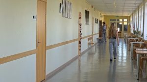 Skolēni dodas pa Jelgavas Spīdolas Valsts ģimnāzijas gaiteni, kur redzamas klašu durvis, soli un atpūtas vietas.