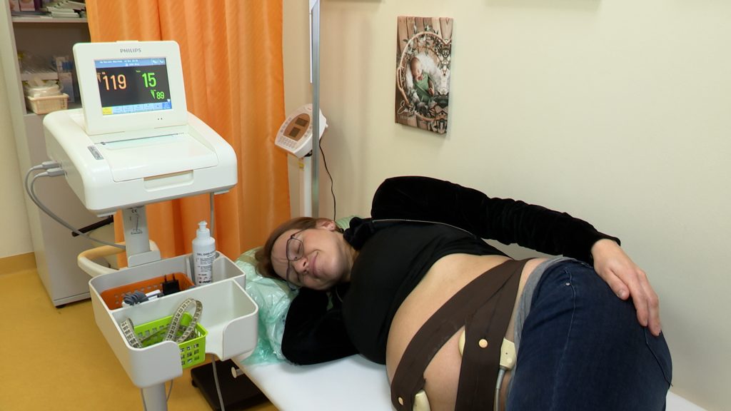Grūtniece guļ uz sāniem medicīniskās izmeklēšanas laikā.