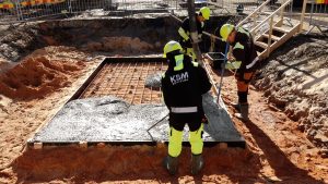 Būvnieki betonē topošās ēkas pamatus būvlaukumā