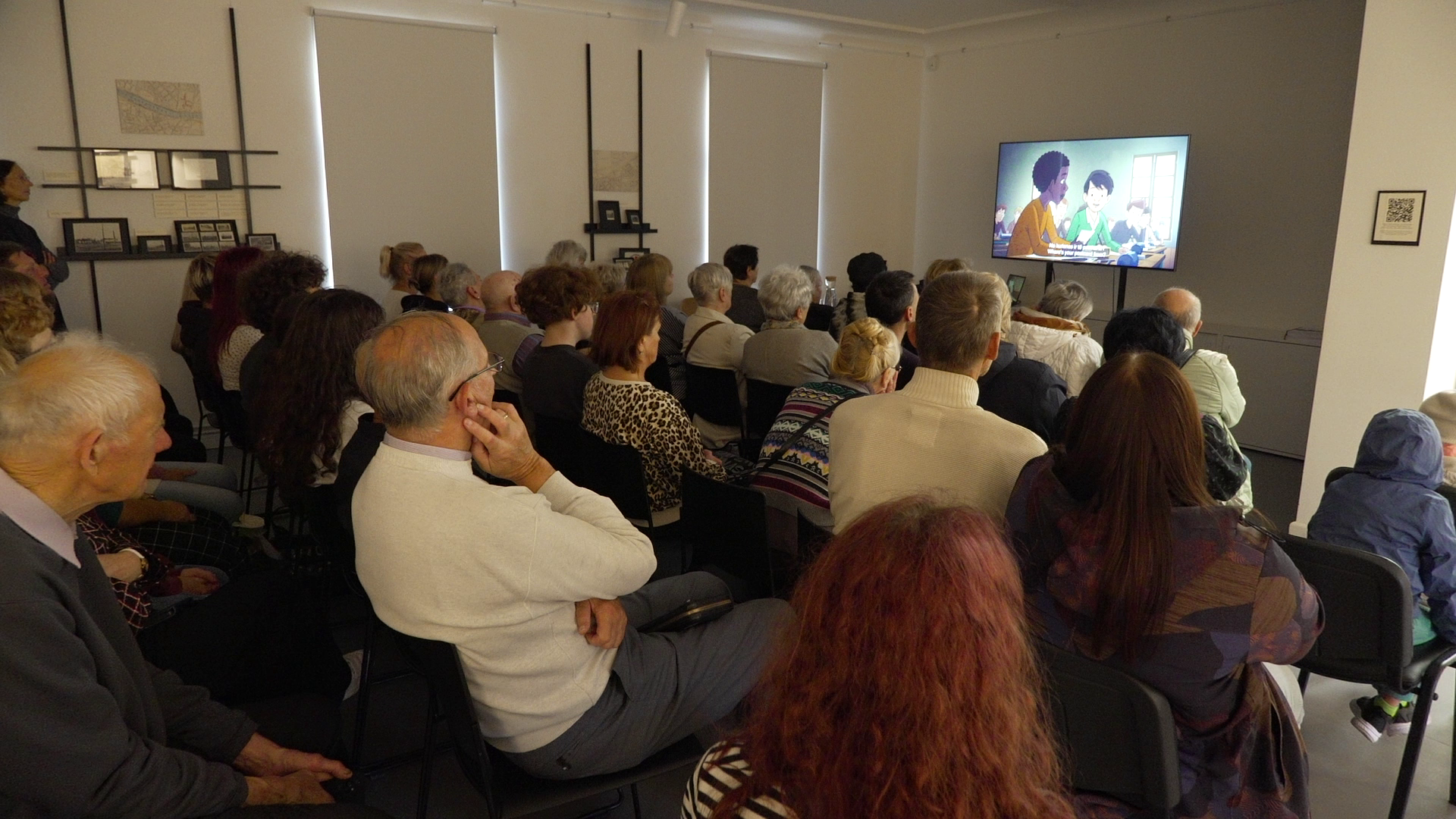 Apmeklētāji Liepājas okupācijas muzejā skatās animācijas filmu “Mana tēva noslēpumi”, kas vēsta par holokausta ietekmi uz nākamajām paaudzēm.