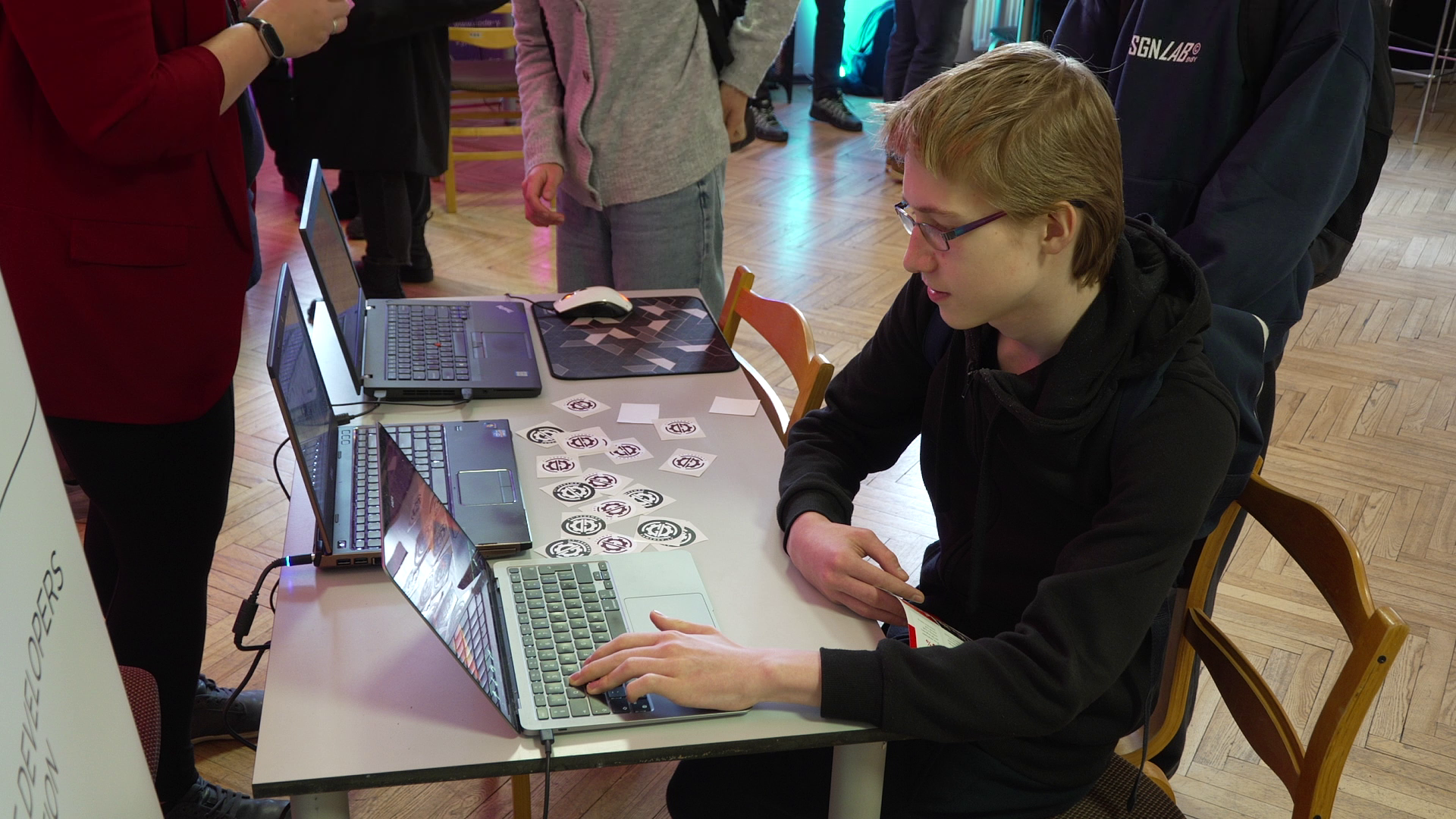 Jaunietis pie klēpjdatora piedalās IT dienas pasākumā Liepājā, iepazīstot digitālās tehnoloģijas un IT nozares iespējas.